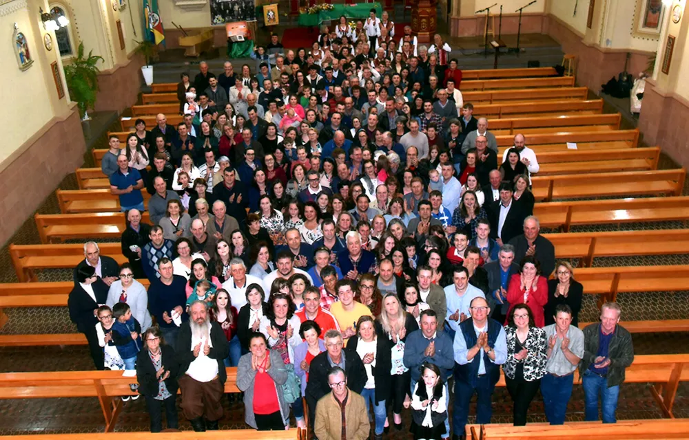 Foto de grupo do Encontro da Família Carlesso dentro da igreja, com centenas de pessoas reunidas entre os bancos.