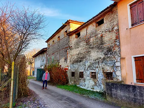 A antiga casa de tijolos da Família Carlesso em Bessica di Loria, na Itália, vista da estrada estreita ao lado.
